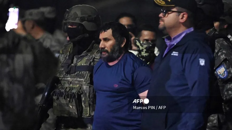 El narcotraficante Adolfo Macías, alias Fito, es custodiado por el ministro del Interior de Ecuador, John Reimberg (R), y personal militar a su llegada a la base aérea de Guayaquil, Ecuador, el 25 de junio de 2025, luego de su recaptura en Manta, provincia de Manabí.