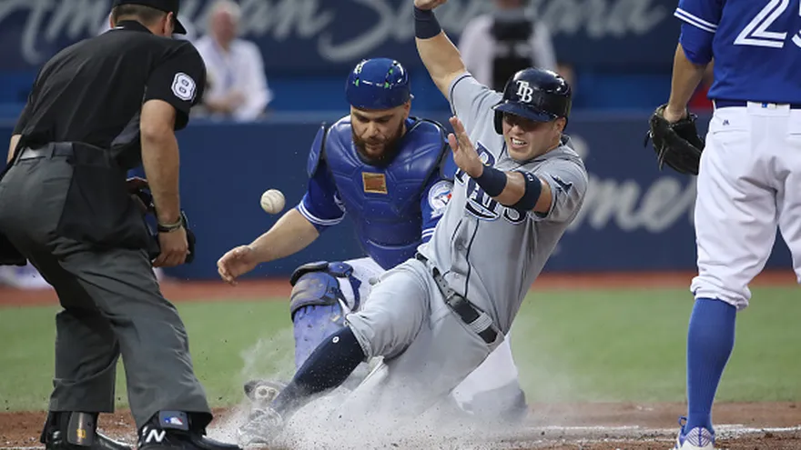 Corey Dickerson, de los Rays, se desliza en el 'home plate'