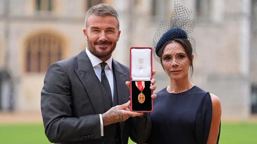David Beckham (i) y su esposa Victoria (d) posan con la medalla condecorativa