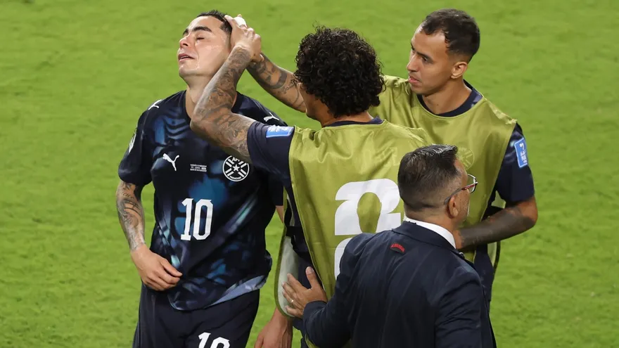 Miguel Almirón (i) se lamenta de su expulsión mientras dos de sus compañeros tratan de consolarlo