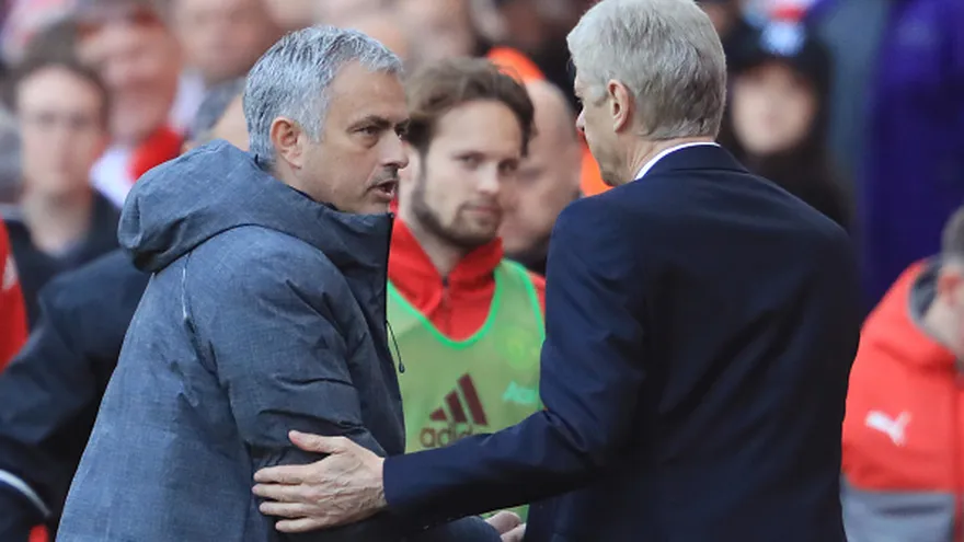Arsene Wenger (de espalda) y Jose  Mourinho (de frente) se saludan