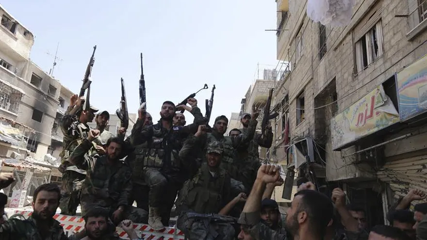 Soldados de las Fuerzas Armadas sirias patrullan por la ciudad de Mleha, en las afueras de Damasco.