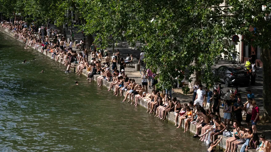 Los bañistas toman el sol a orillas del Canal Saint-Martin mientras Francia sufre una ola de calor