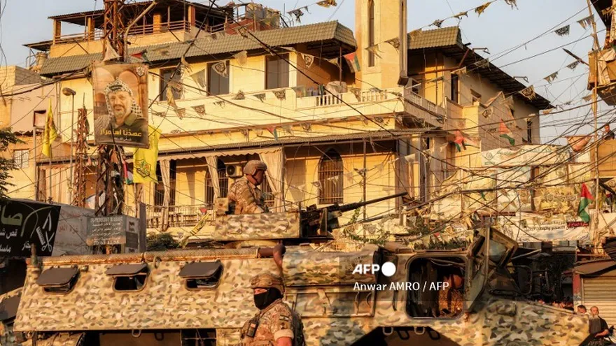 Soldados del ejército libanés junto a un vehículo blindado de transporte de personal estacionado en el campamento Burj al-Barajneh para refugiados palestinos, en los suburbios del sur de Beirut, el 21 de agosto de 2025, mientras los grupos palestinos armados en los campamentos de refugiados comienzan a entregar sus armas a las autoridades libanesas luego de un acuerdo alcanzado en mayo.