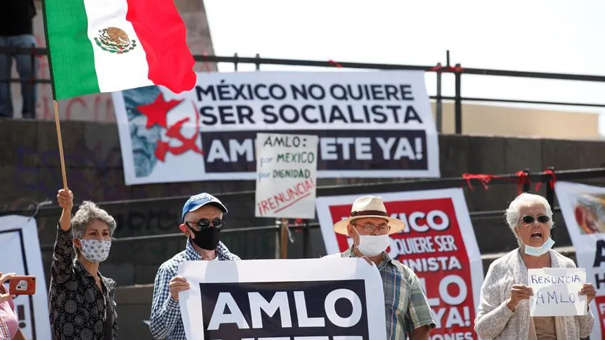 Personas sostienen carteles y banderas este sábado durante una protesta contra el gobierno de Andrés Manuel López Obrador, en una avenida de Guadalajara, estado Jalisco (México)
