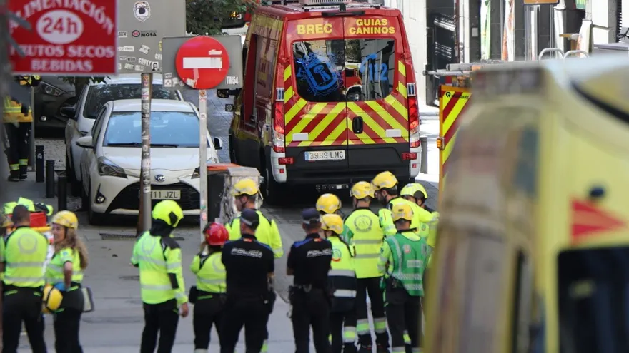 Bomberos y personal de seguridad tras el derrumbe de un edificio en Madrid