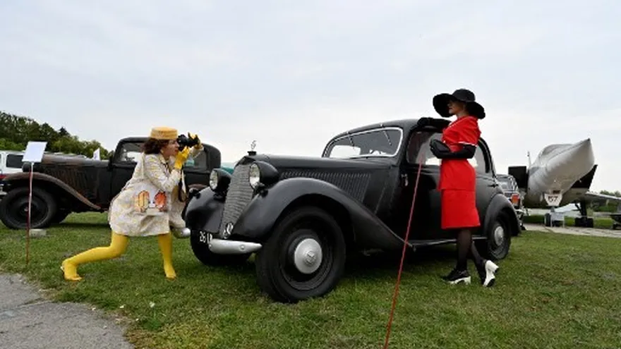Foto ilustrativa: Una mujer posa frente a un coche de exhibición en Kiev