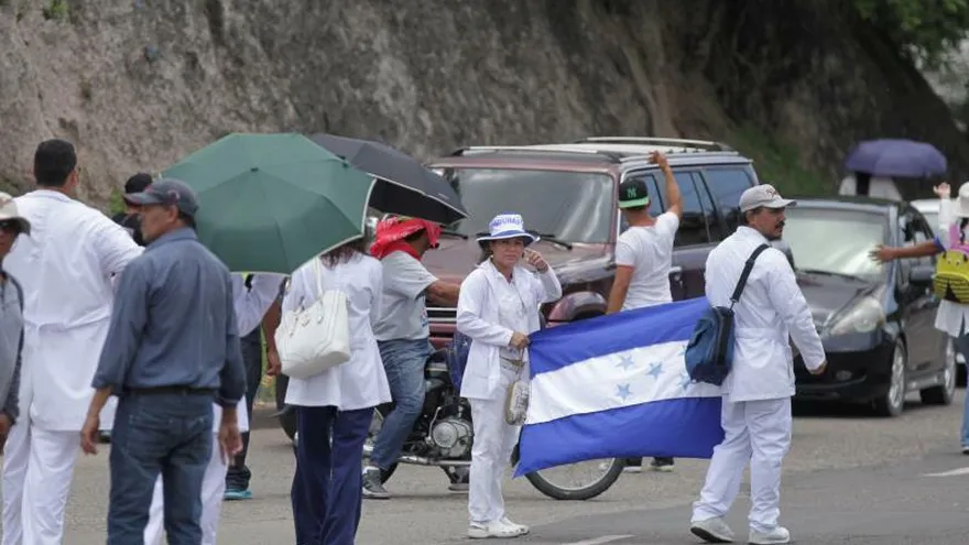 Un grupo de estudiantes de medicina se unen a cientos de maestros y médicos de Honduras este lunes durante una protesta en rechazo a dos leyes asociadas a educación y salud pese a que el Gobierno anunció su derogación, en Tegucigalpa (Honduras).