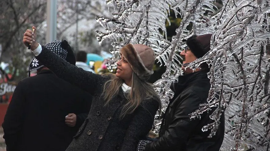 Fotografía cedida por el portal On Jack que muestra a turistas posando junto a árboles con nieve en São Joaquim, en el estado de Santa Catarina (Brasil).