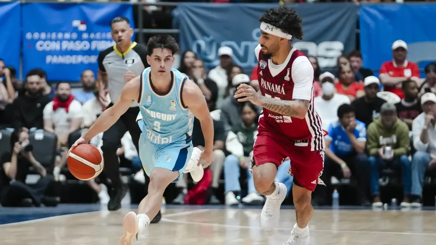 Jhivvan Jackson (d) sigue de cerca a Lucas Capalbo (i) durante el partido entre Panama y Uruguay