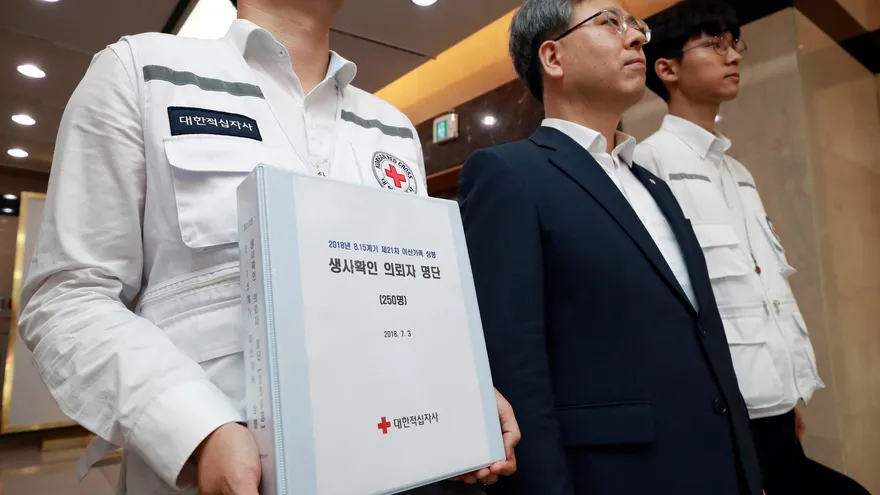 Un trabajador de la Cruz Roja sostiene un documento con la lista de candidatos para asistir a las reuniones familiares entre las dos coreas en Seúl (Corea del Sur) este 3 de julio