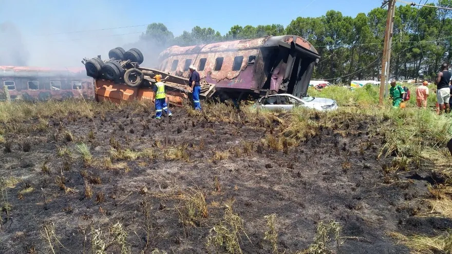 Varios miembros de los servicios de rescate inspeccionan los restos de un tren intercity que descarriló tras chocar con un camión que cruzaba las vías en Kroonstad (Sudáfrica) este 4 de enero