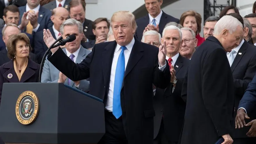El presidente de los Estados Unidos, Donald Trump (c-i), acompañado del senador republicano de Utah y presidente del Comité de Finanzas del Senado, Orrin Hatch (d), e integrantes republicanos de la Cámara y el Senado, pronuncia un discurso sobre la aprobación de la reforma fiscal, este miércoles 20 de diciembre de 2017, en el ala sur de la Casa Blanca, en Washington (DC, EE.UU.).