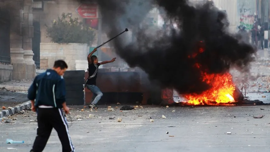 Lanzan piedras hacia las fuerzas de seguridad israelíes durante los enfrentamientos en la entrada principal de la ciudad cisjordana de Belén el 6 de octubre de 2015, tras el funeral de 13 años de edad, Abdel Rahman Abdullah palestina .
