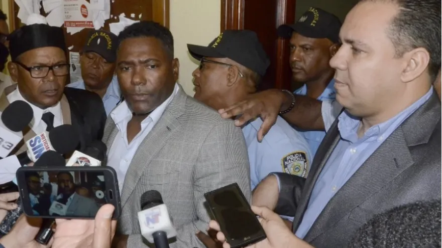 Miguel Tejada (c) cuando era abordado por los periodistas en las audiencias