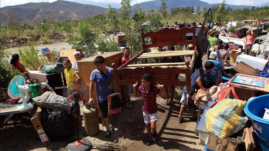 Cientos de colombianos cargan sus pertenencias por el río Tachira desde Venezuela hacia el sector La Parada (Colombia), este 25 de agosto, en Cúcuta.