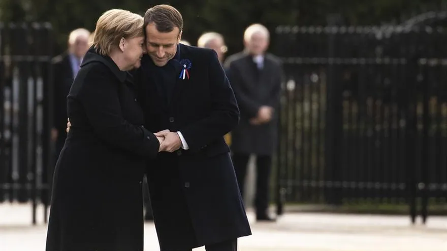 El presidente francés, Emmanuel Macron (d), y la canciller alemana, Angela Merkel (i), asisten a una ceremonia en el bosque del Bosque de Rethondes en Compiegne, Francia.
