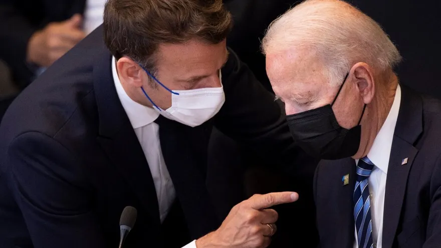 Biden (der.) y Macron hablan.
