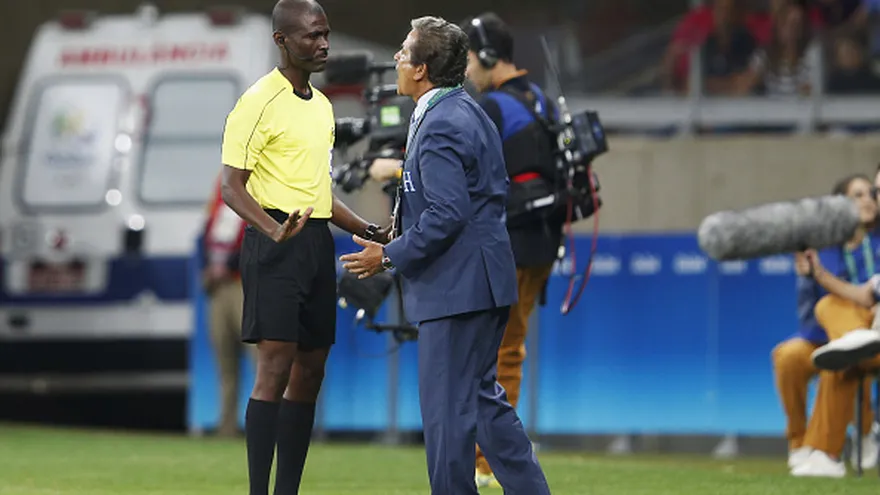 Joseph Lamptey (i) escucha al técnico de Honduras, Jorge Luis Pinto (d)