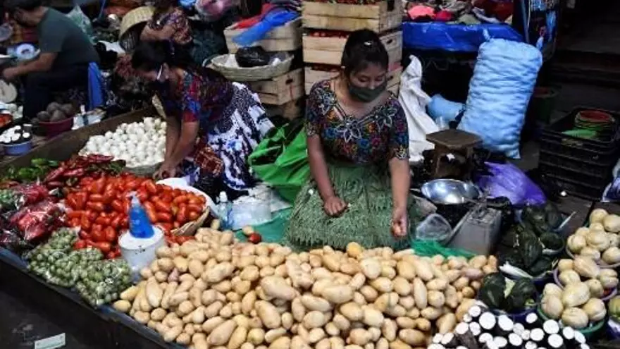 Una mujer vende productos en un mercado en Guatemala