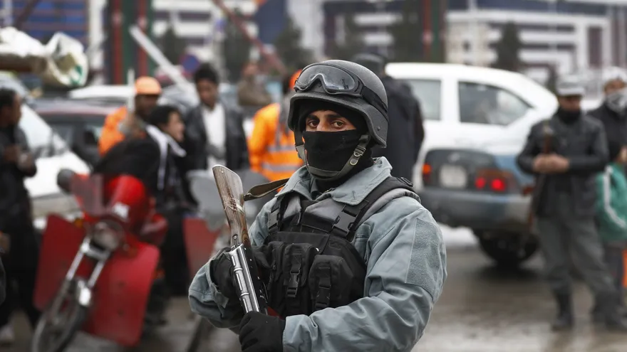 Oficiales de seguridad inspeccionan el lugar de un ataque cerca del aeropuerto de Kabulk (Afganistán).