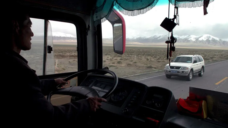 Un conductor chino conduce un autobús de pasajeros a lo largo de la carretera Qinghai Tíbet cerca de la ciudad Golmud, provincia de Qinghai, China.