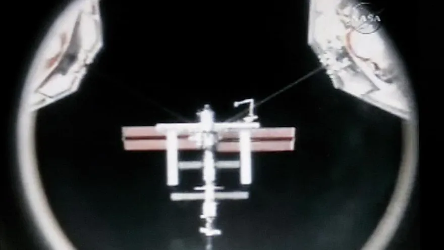 Fotografía proporcionada por NASA TV que muestra la Estación Espacial Internacional a través de la cámara de acople del transbordador espacial Atlantis.