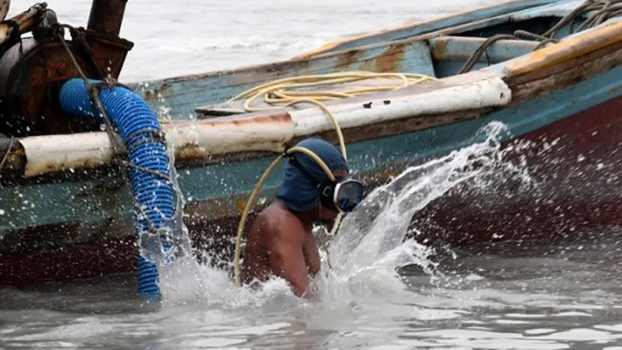 Paci entra al agua a bucear, para buscar el estaño.