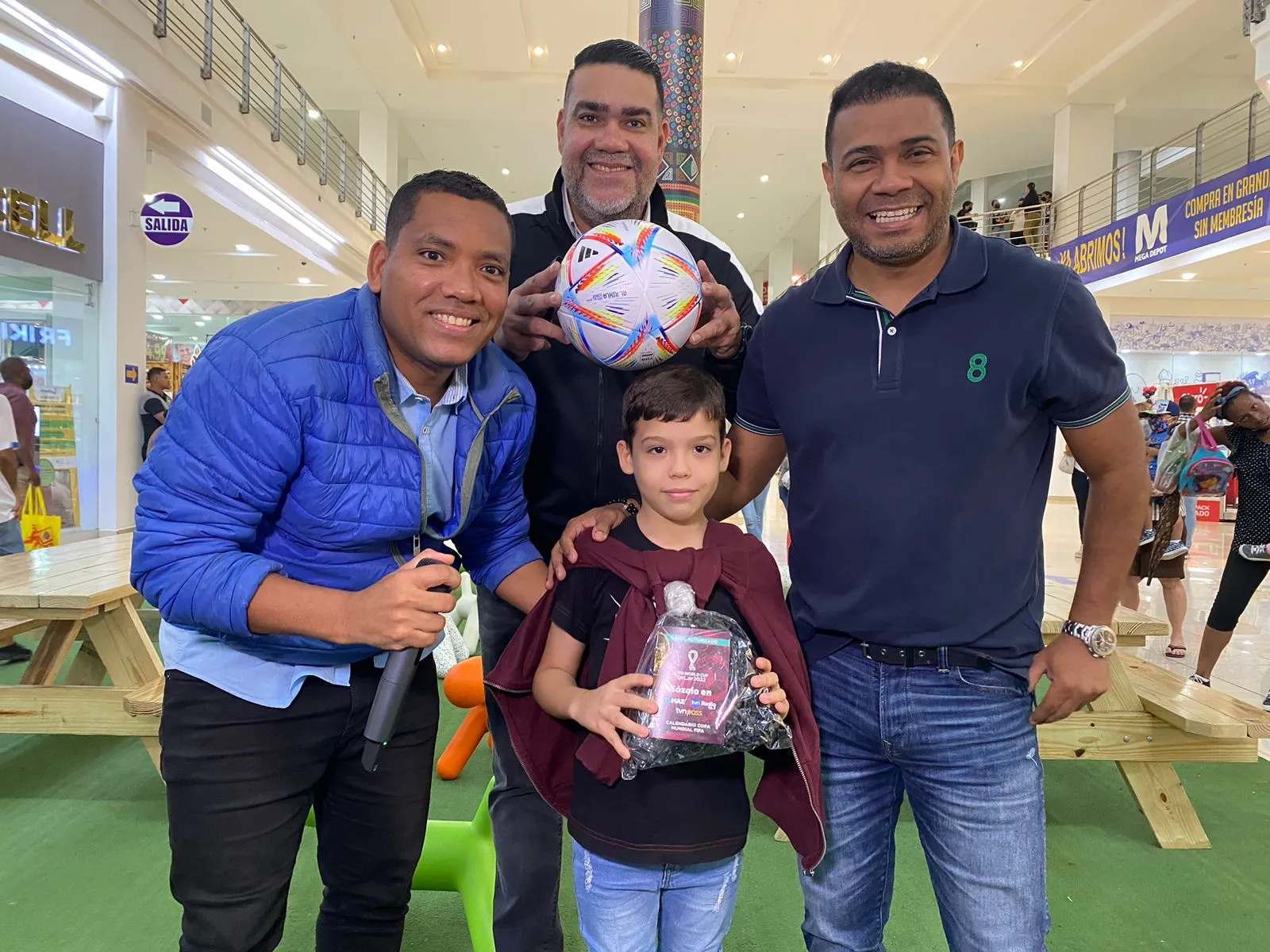 Jhony Mosquera (i), Julio Shebelut (c) y Roberto Rivera junto a un niño presente en Los Andes Mall