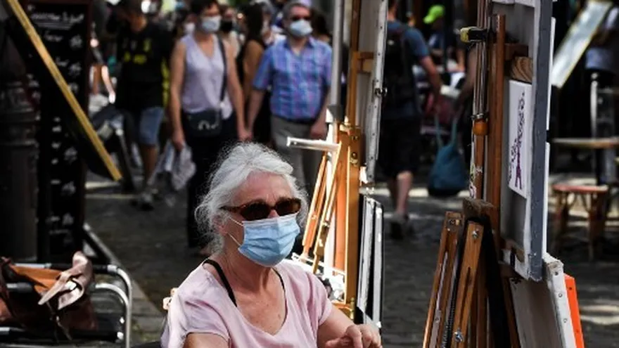 Personas con mascarillas caminan por las calles de París