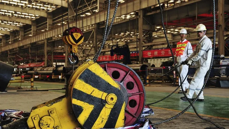 Un par de operarios trabajan en una filial de la compañía China Offshore Oil Engineering en Qingdao, China.