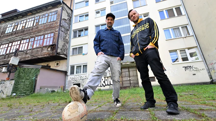Los integrantes de la banda bosnia de hip-hop Dubioza Kolektiv, Brano Jakubovic (izq.) y Vedran Mujagic, posan con un balón en el patio trasero de un bloque de apartamentos en Sarajevo, el 2 de junio de 2026.
