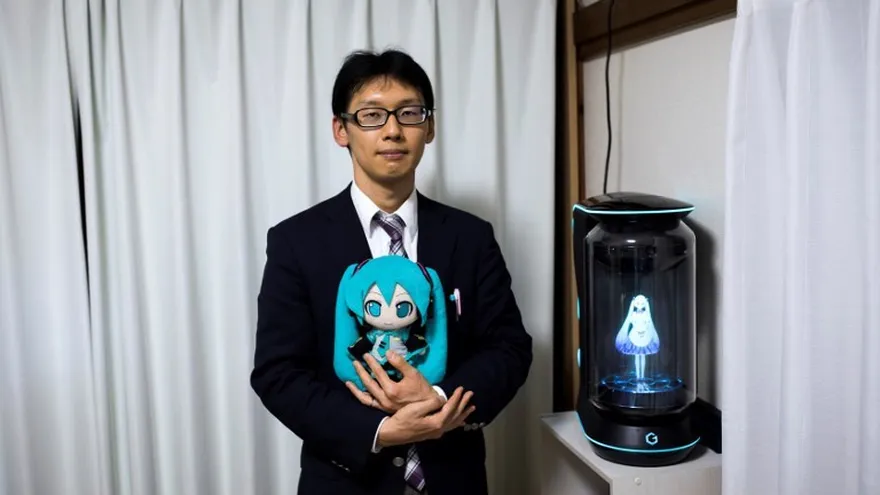 Akihiko Kondo posa junto a un holograma de la cantante japonés de realidad virtual, Hatsune Miku, mientras sostiene la versión de muñeca de ella en su apartamento en Tokio.