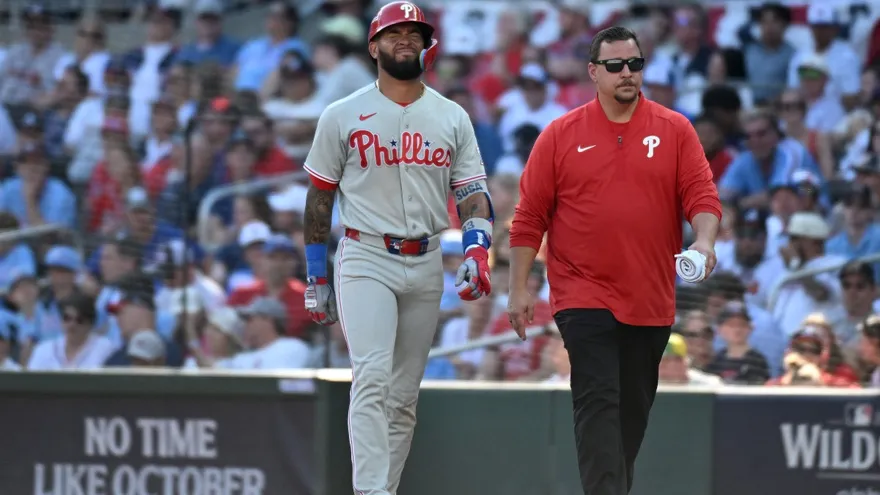 Edmundo Sosa hace un gesto de dolor mientras sale del terreno de juego del Truist Park de Atlanta