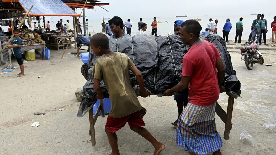 Varios comerciantes retiran sus pequeños puestos cerca de una playa en Patenga, Chottagong (Bangladesh)