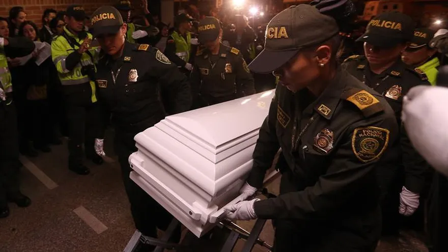 Integrantes de la policía colombiana trasladan el cuerpo de la niña Yuliana Andrea Samboní, de siete años de edad.