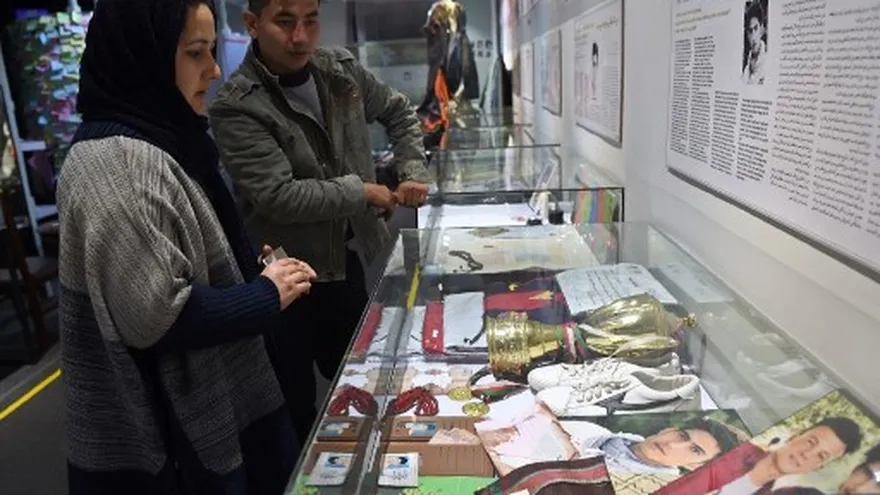 Una mujer y un hombre observan recuerdos de las víctimas