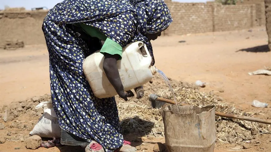 Una mujer se abastece de agua
