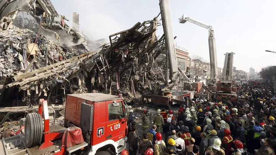 Miembros de los servicios de rescate iraníes buscan posibles víctimas entre los escombros del edificio Plasco después de que se derrumbase como consecuencia de un grave incendio, en Teherán (Irán), hoy, 19 de enero de 2017.