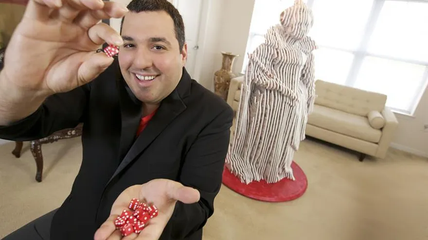 El artista colombiano Mateo Blanco, que usa objetos y elementos de la naturaleza para crear sus obras, dejó instalada esta semana en Orlando (Florida) una "Reina de corazones" (d) hecha con miles de naipes y dados.