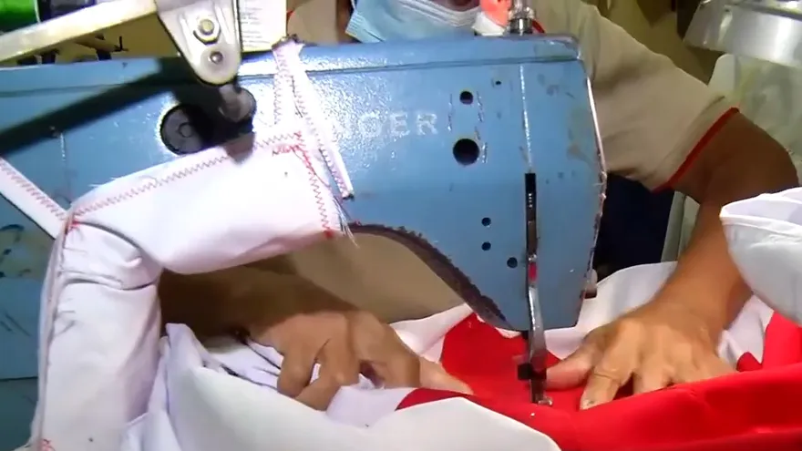 Las manos que confeccionan listones y banderas de Panamá