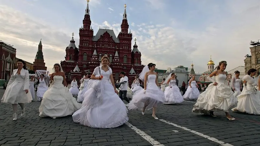 Novias caminan en la Plaza Roja de Moscú, Rusia.