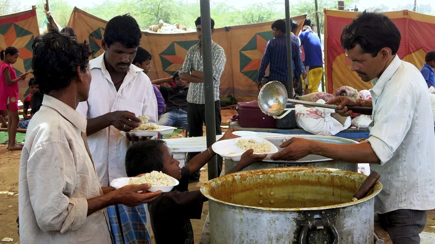 Reparto de comida a los habitantes del barrio de chabolas del sur de Nueva Delhi