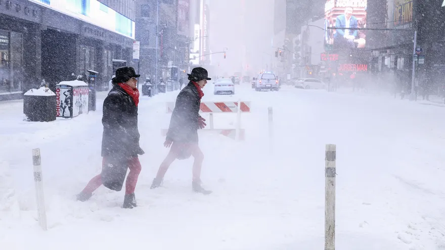 La gente camina por la Sexta Avenida mientras cae nieve en la ciudad de Nueva York el 25 de enero de 2026.