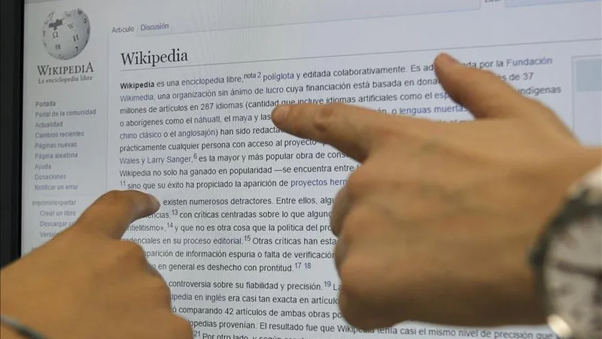 Dos usuarias consultan en internet la enciclopedia libre digital Wikipedia, en versión española.