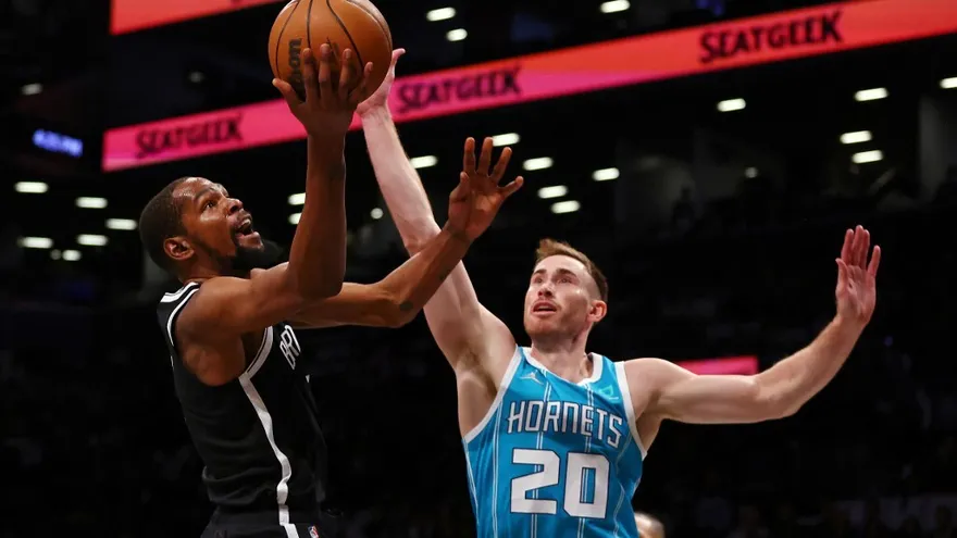 Kevin Durant (i) trata de hacer un tiro ante la cobertura de Gordon Hayward (d)