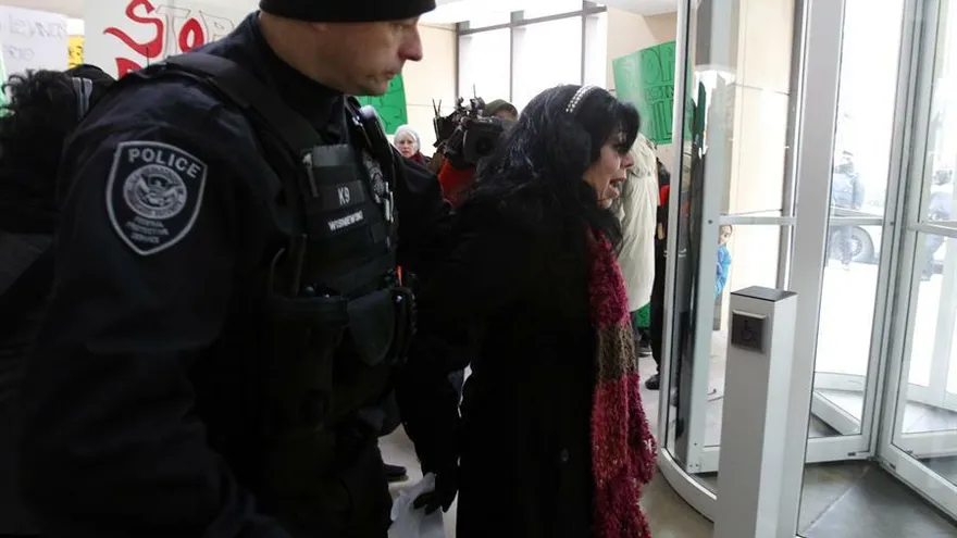 Fotografía donde se observa a un policía mientras de tiene a una mujer sin documentos