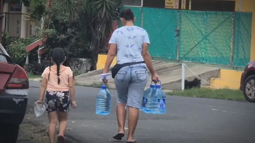 Personas cargan botellas con agua