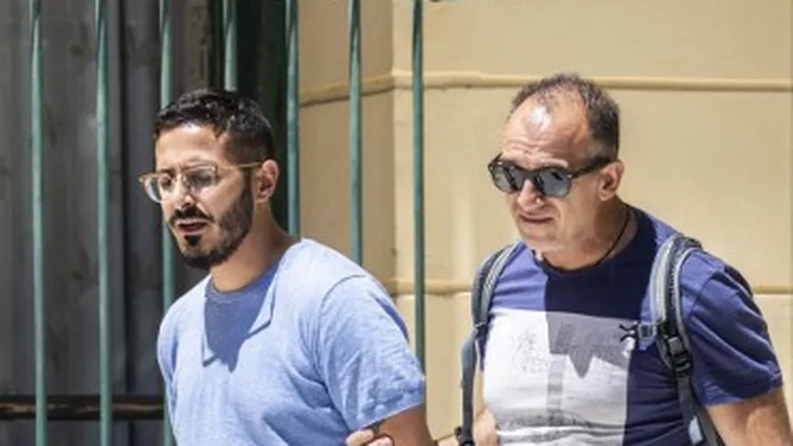 La foto tomada el 1 de julio de 2019 muestra al llamado "estafador de Tinder" (izquierda) mientras es expulsado de la ciudad de Atenas, Grecia