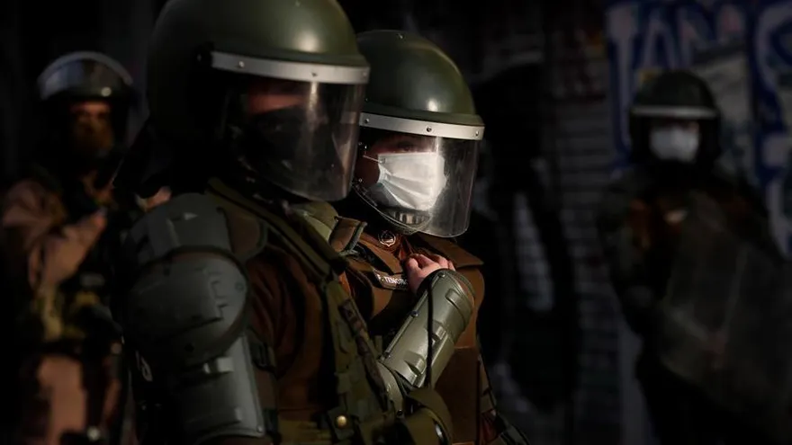 Policías vigilan a los manifestantes este lunes durante las protestas contra el Gobierno de Sebastián Piñera y por la celebración del día del Carabinero